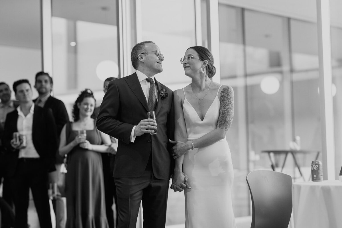 Black and white image of couple looking at each other during toasts