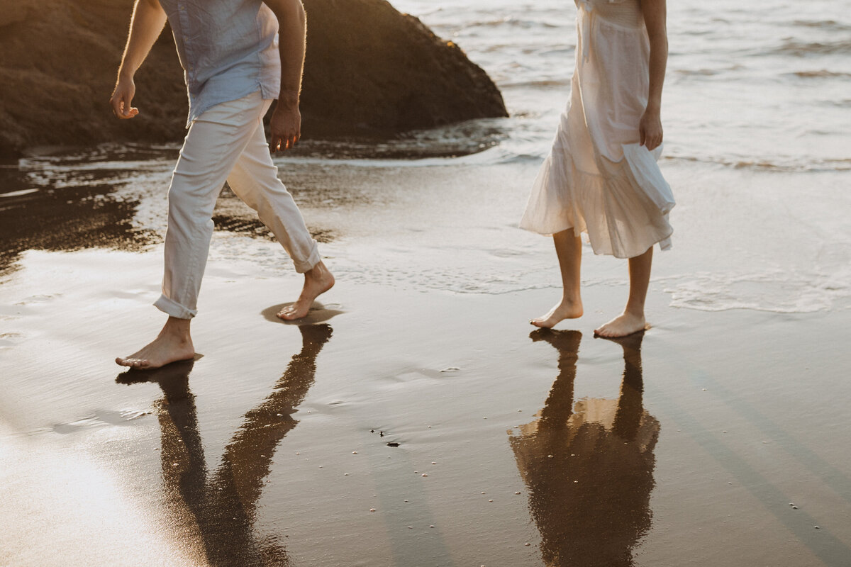 Couple's legs shown walking barefoot o