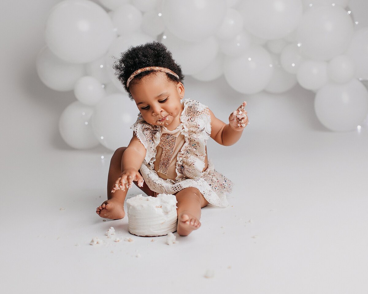  Baby wearing pink tutu during first birthday cake smash session