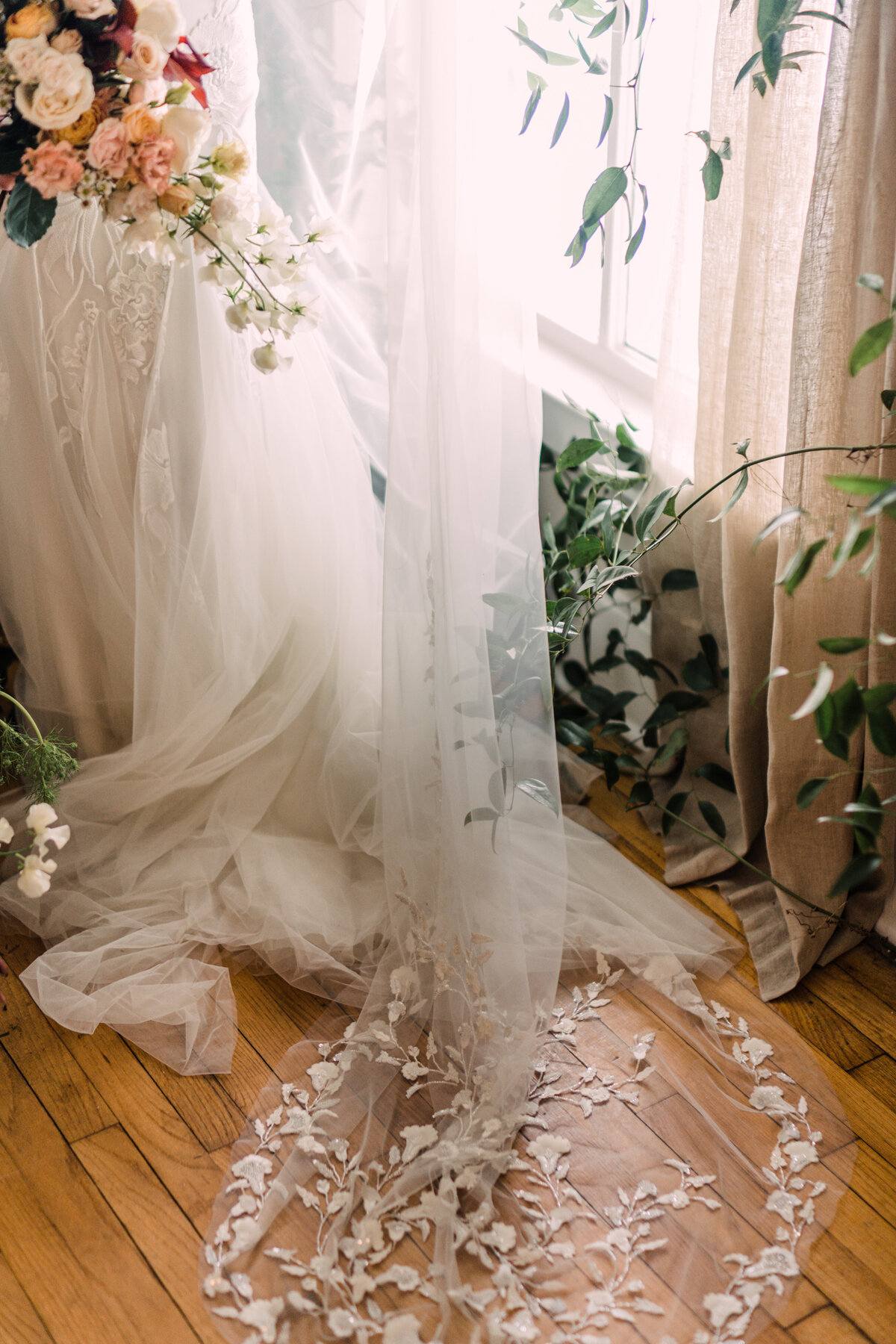Alexandra Grecco Ainsley veil with floral applique and lace by vine-covered window in natural light