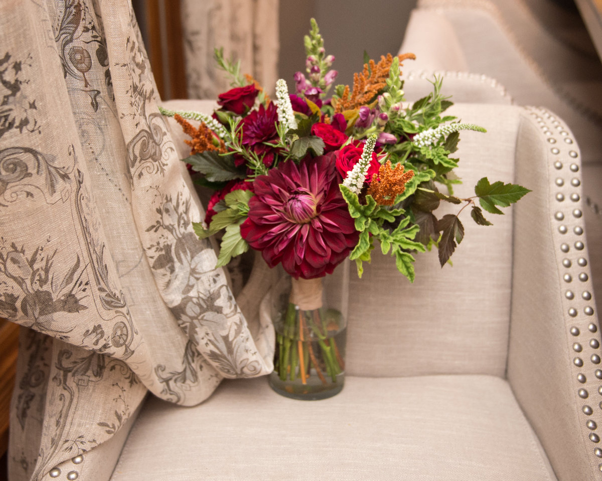 bouquet in jar on tack nail chair with curtain drape