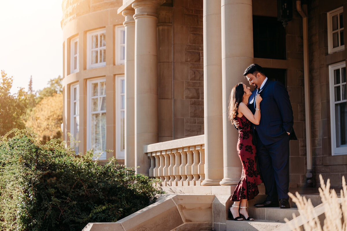 Engaged couple looks at each other in front of Government House in Edmonton, Alberta