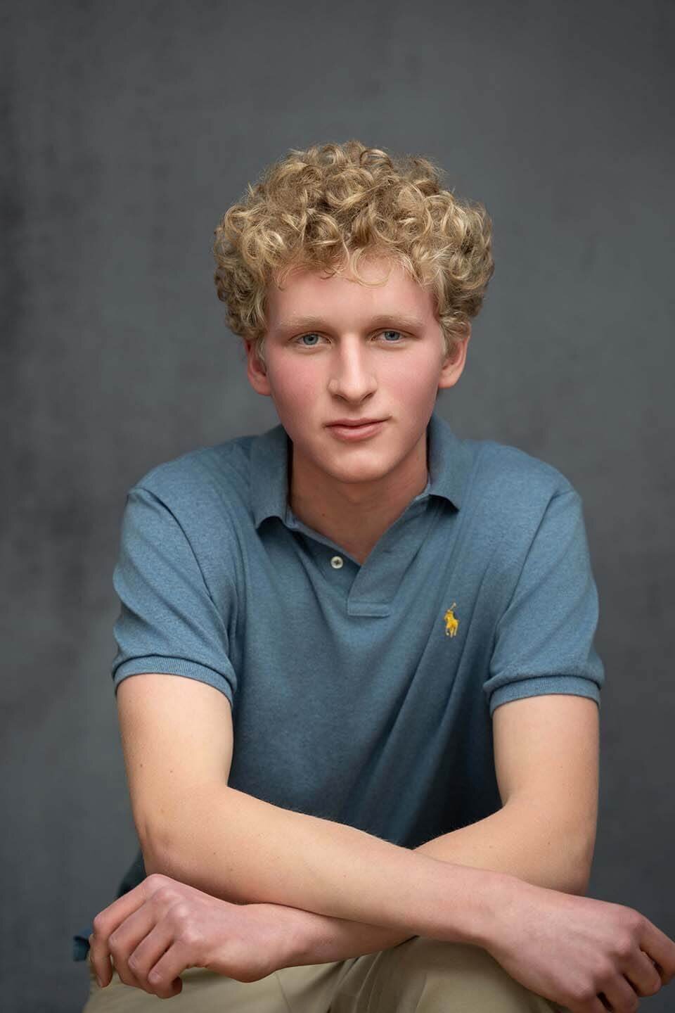 senior-boy-posed-in-studio-on-gray