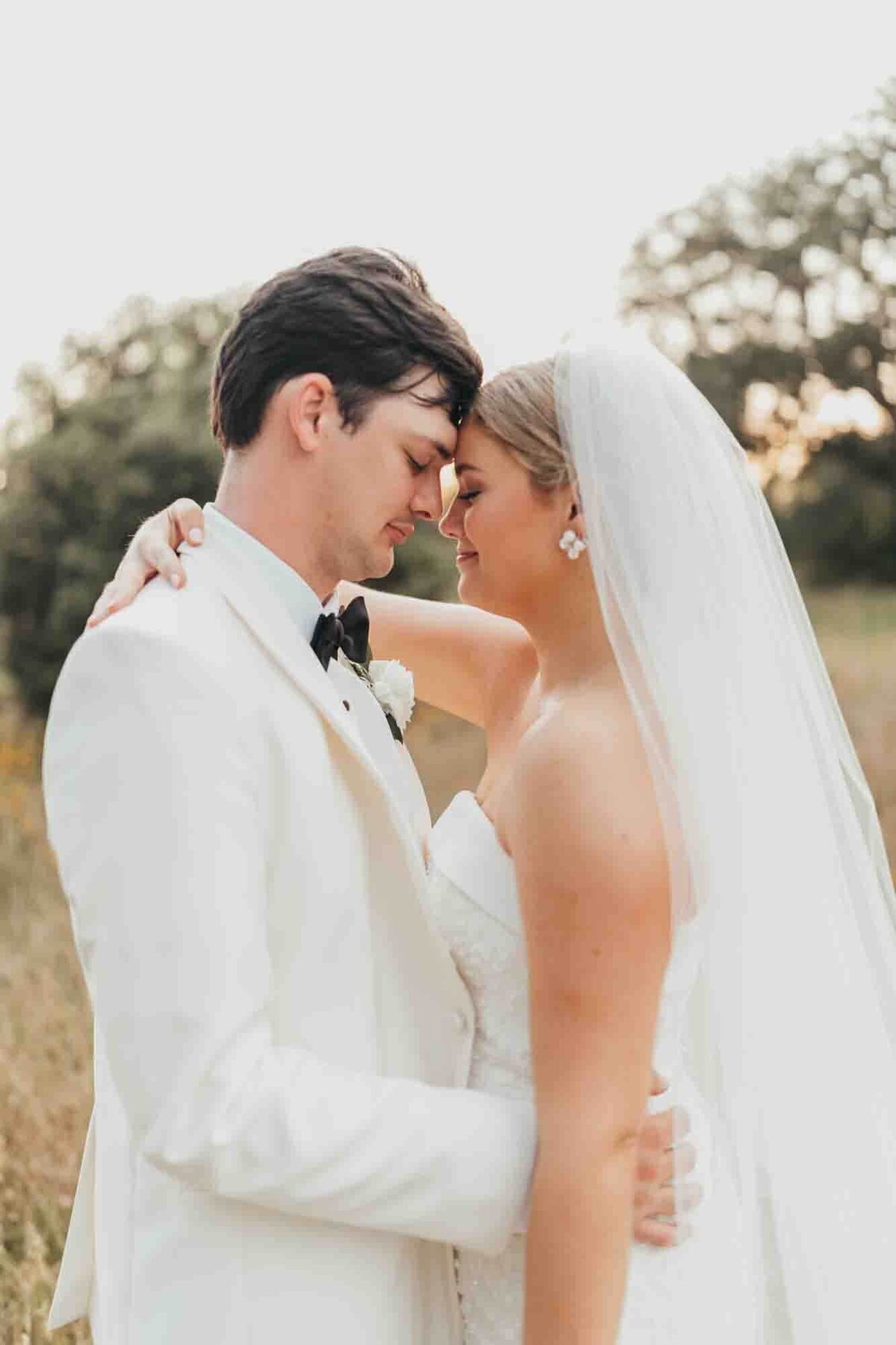 bride and groom touch foreheads during intimate moment together after getting married.