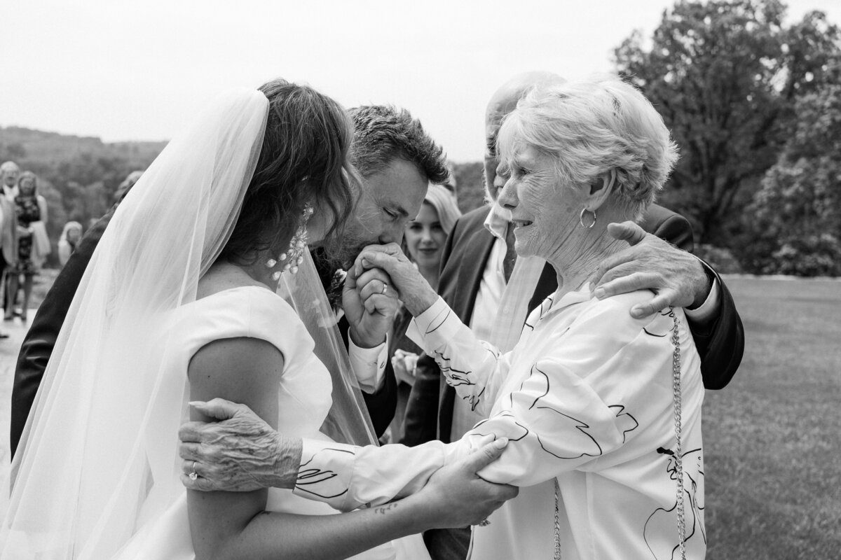 Emotional Bride & Groom greet guests  at their wedding at Bryn Athyn Cathedral in Bryn Athyn, PA