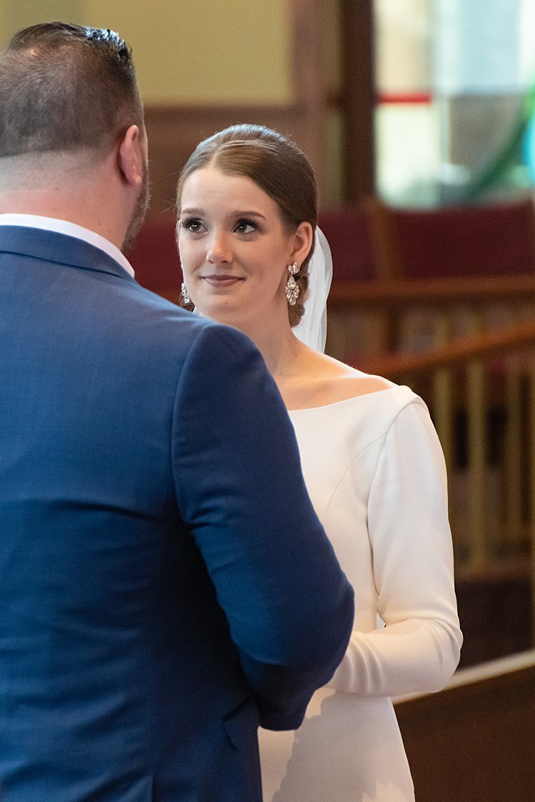 Bride looks lovingly at NFL free agent Groom during their wedding ceremony at St. Bonaventure Church in Pittsburgh, PA