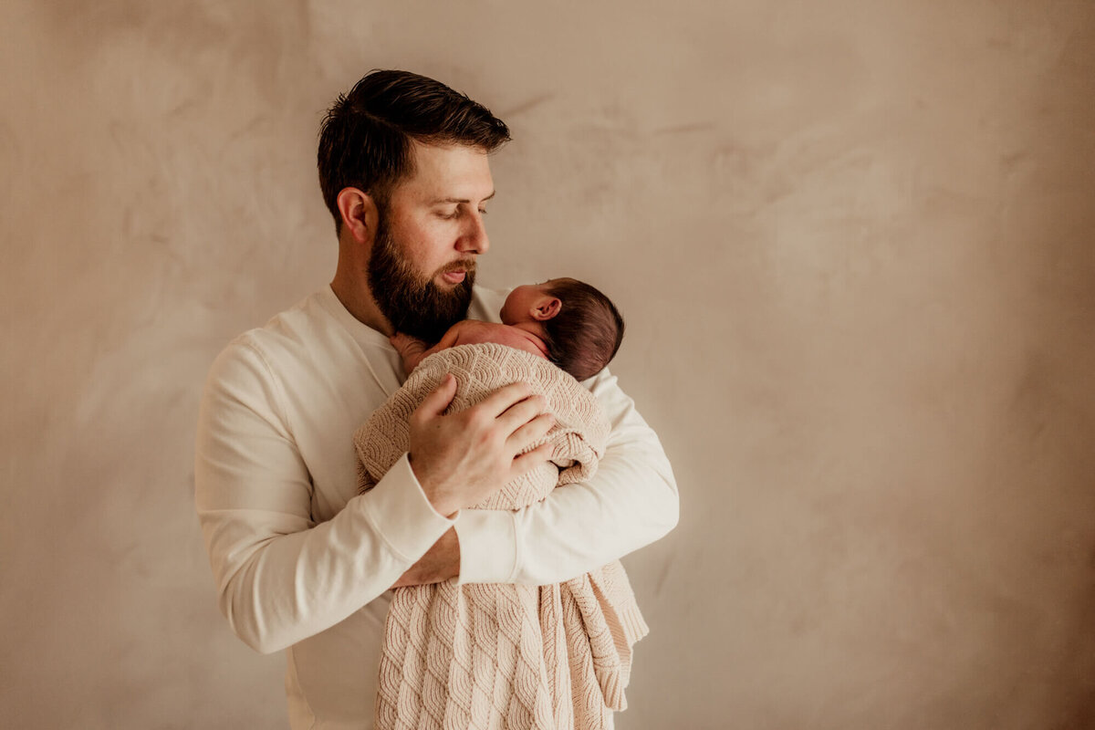 Father burps his baby boy.