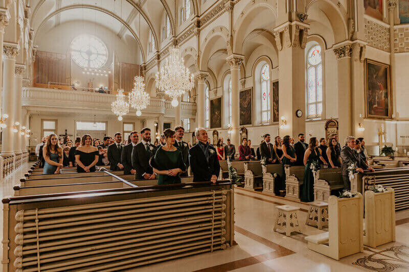 Invités sur les bancs de l'église lors d'une cérémonie de mariage à Montréal. Photo prise par Laura, Photographe mariage.