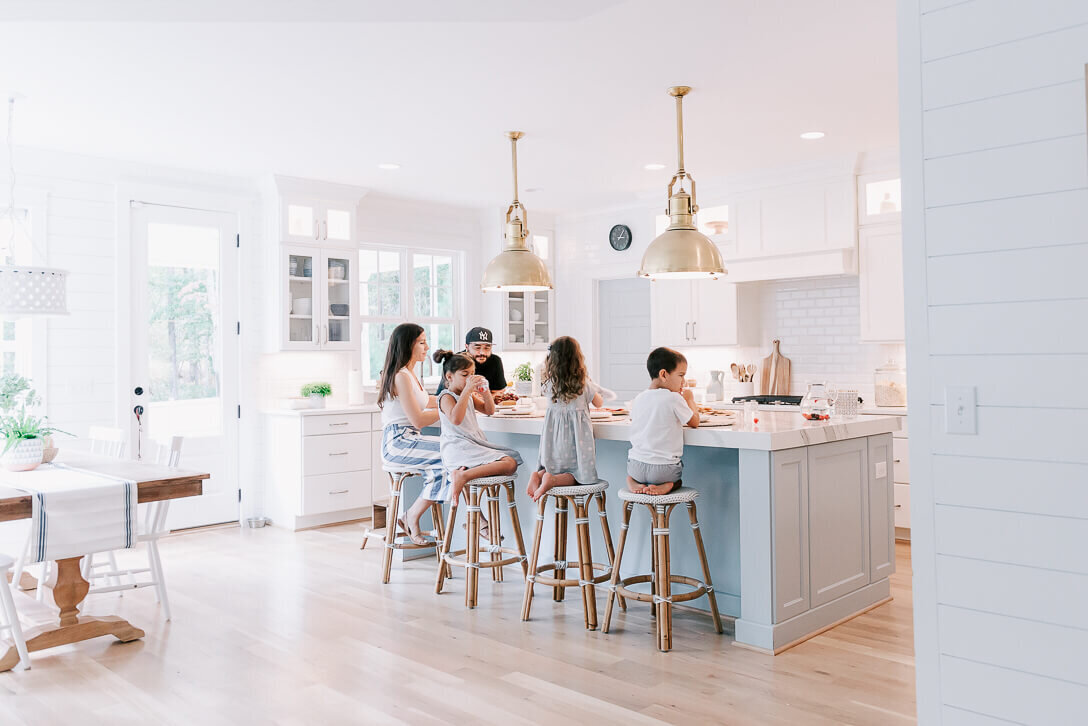 family sitting by a kitchen island on serena and lily stools