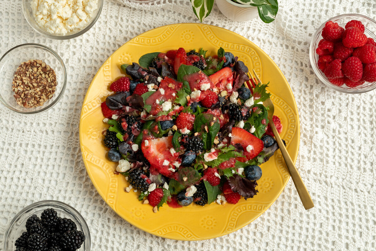 homemade raspberry vinaigrette dressing on a spring mixed berry salad.