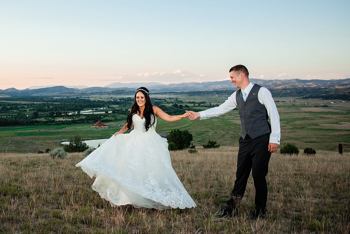 Bride and groom jitterbugging together on the hilltop overlooking Montana valley