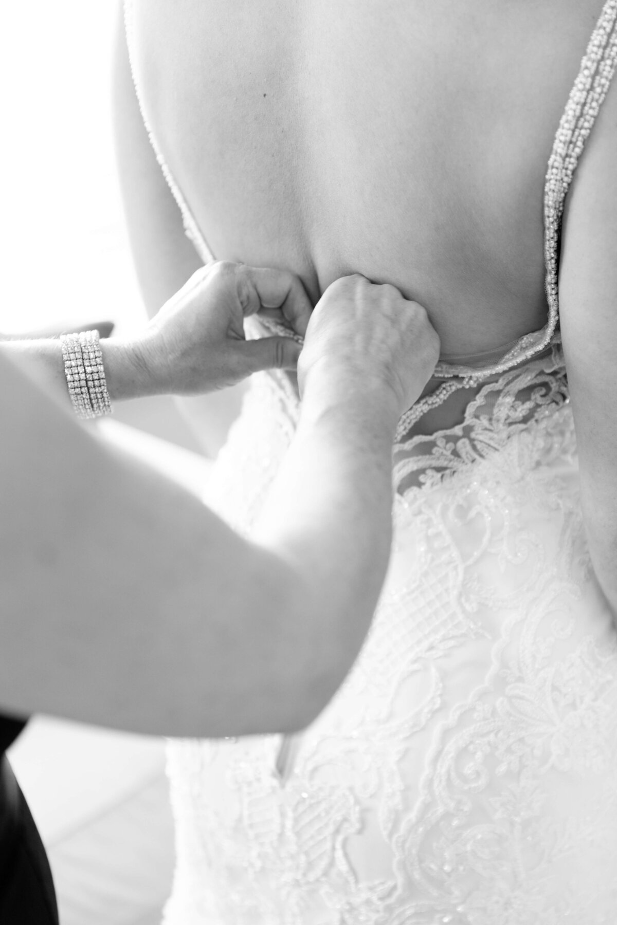 Woman helping bride fix dress