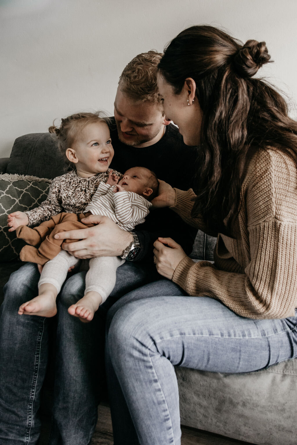 Gezin met newborn baby tijdens ontspannen newbornshoot