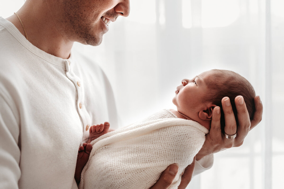 side profile of dad holding swaddled baby by Alyssum, Denver newborn photographer