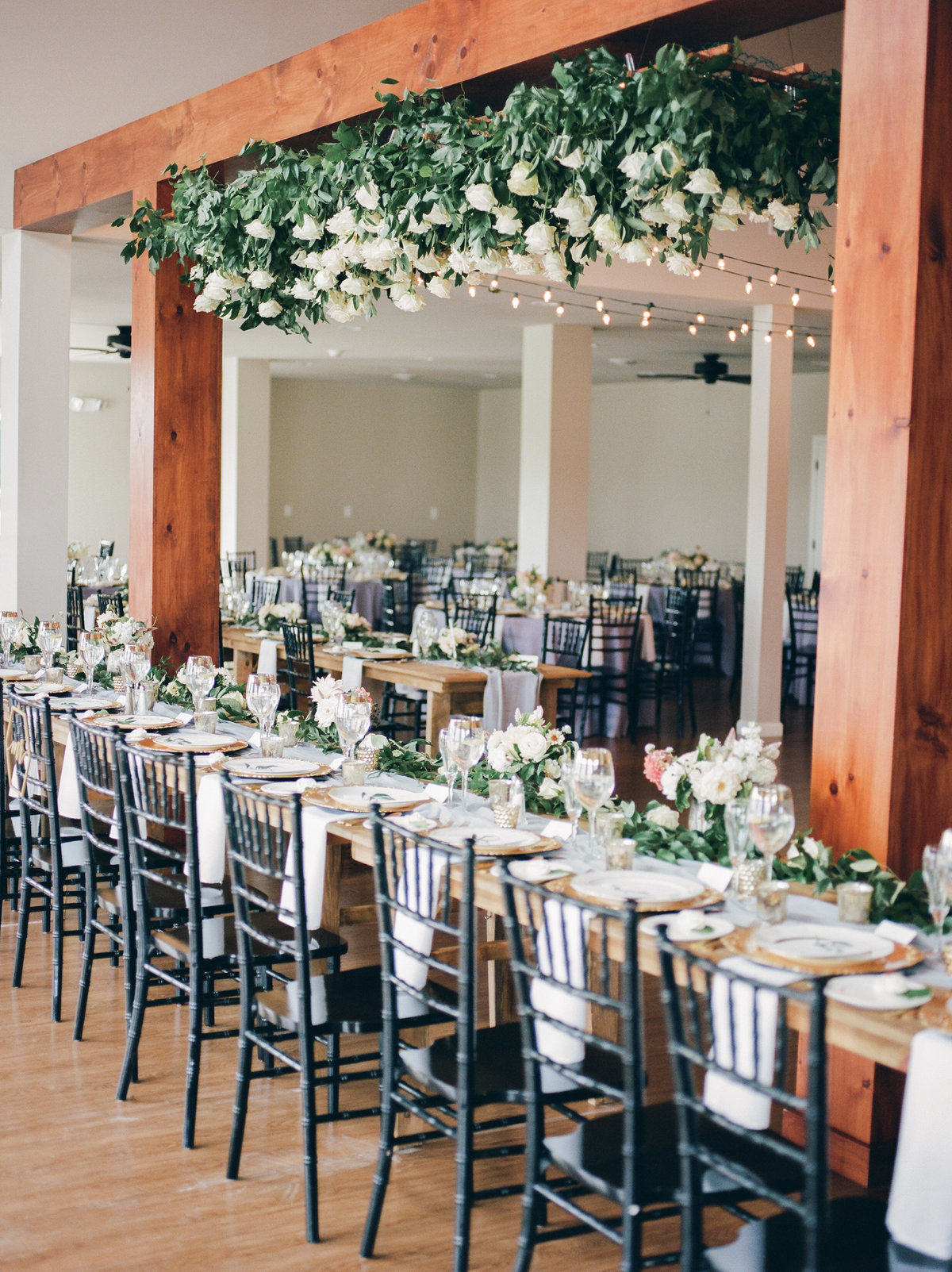 indoor reception with wooden beams and roses hanging from ceiling