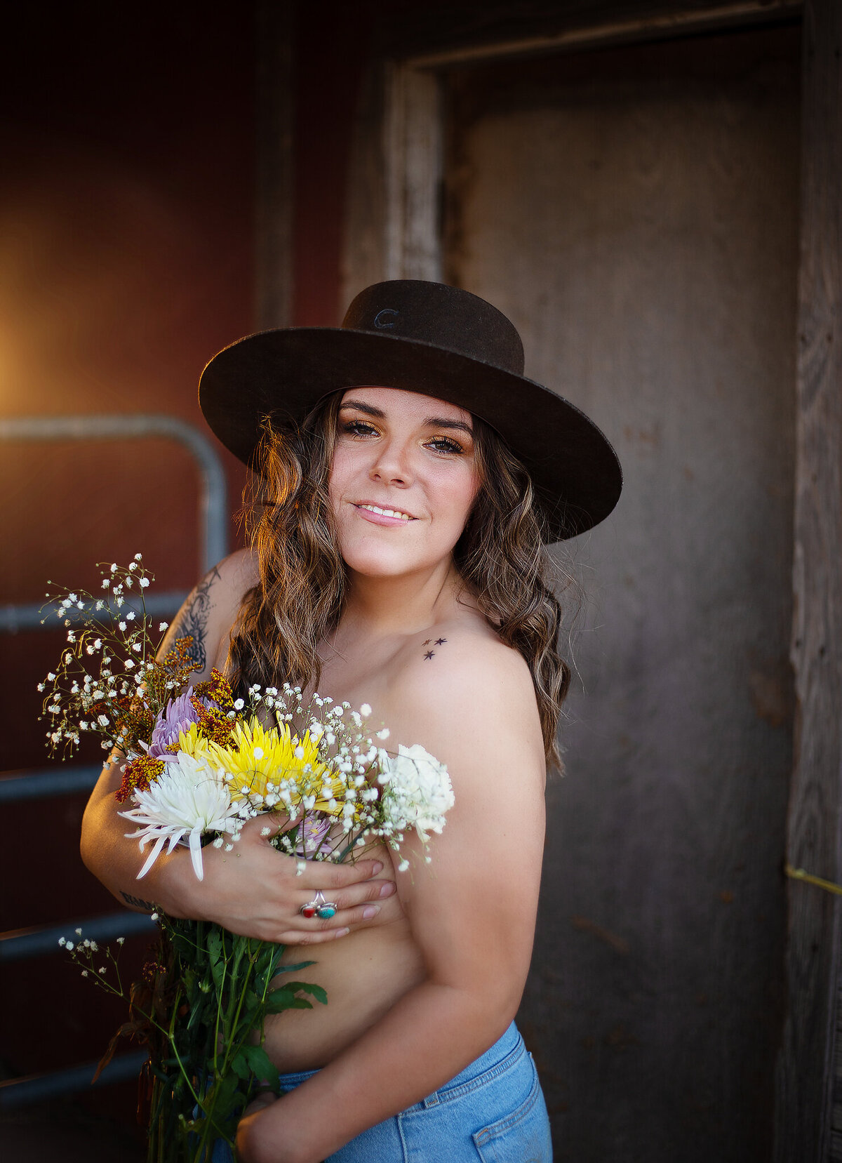 flower bra and charlie hat next to barn boudoir session