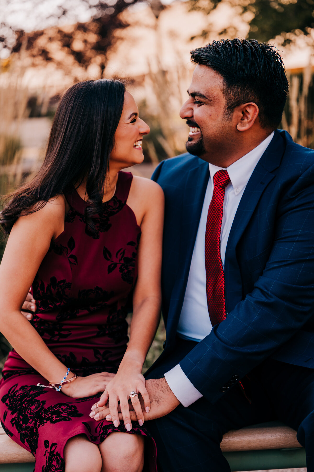couple sitting on bench in a garden looking at each other and smiling