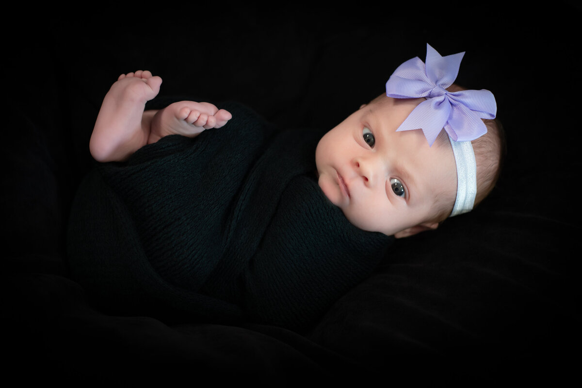 Newborn baby girl in alternative portrait black and purple