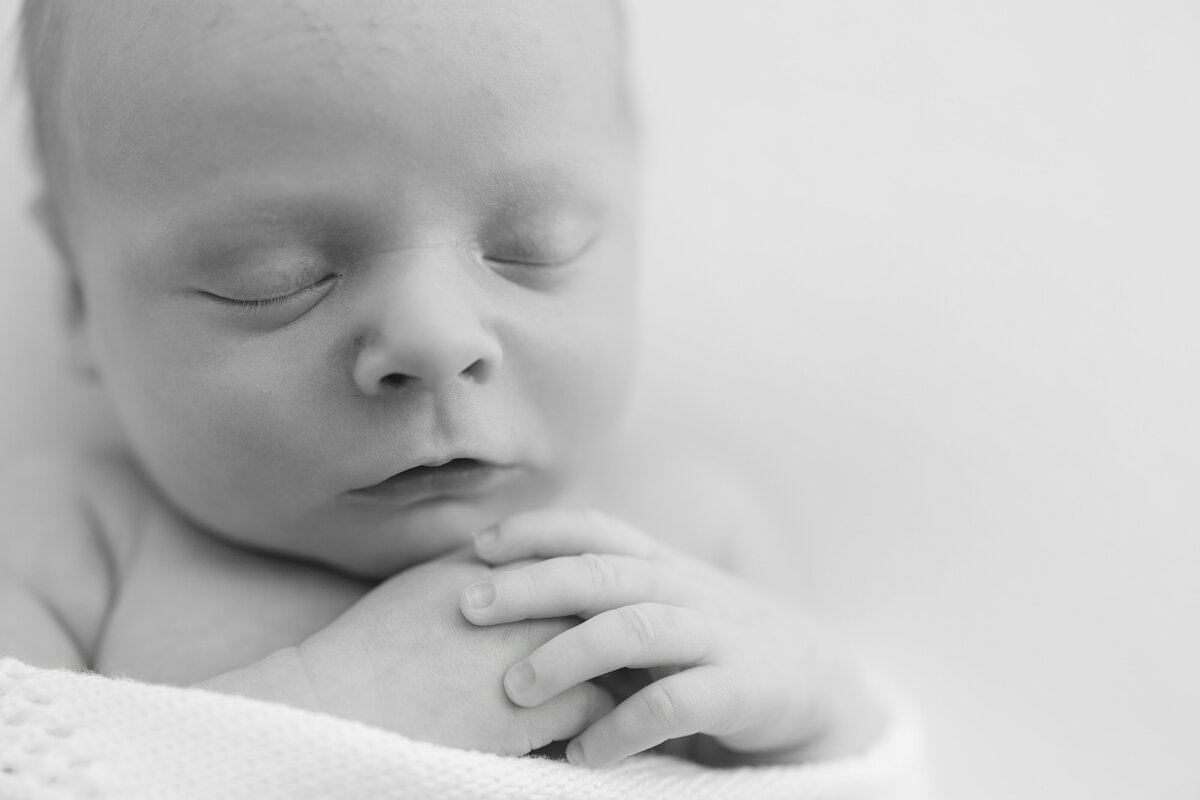 Newborn baby sleeping peacefully on a soft, neutral-toned blanket, captured in natural light during a lifestyle photography session by Little Palm in Mill Valley, California.