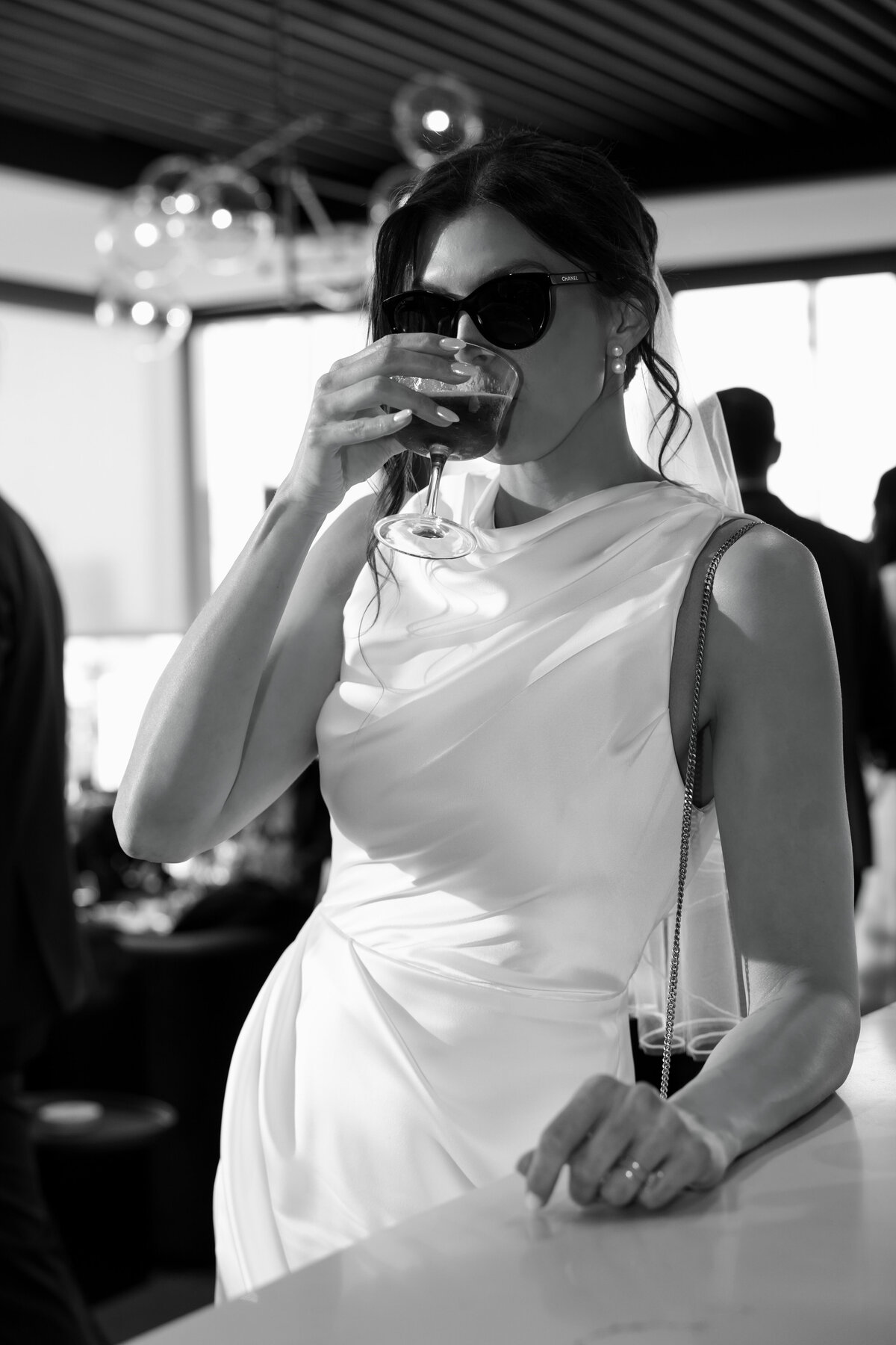 bride posing for wedding photographer with her drink