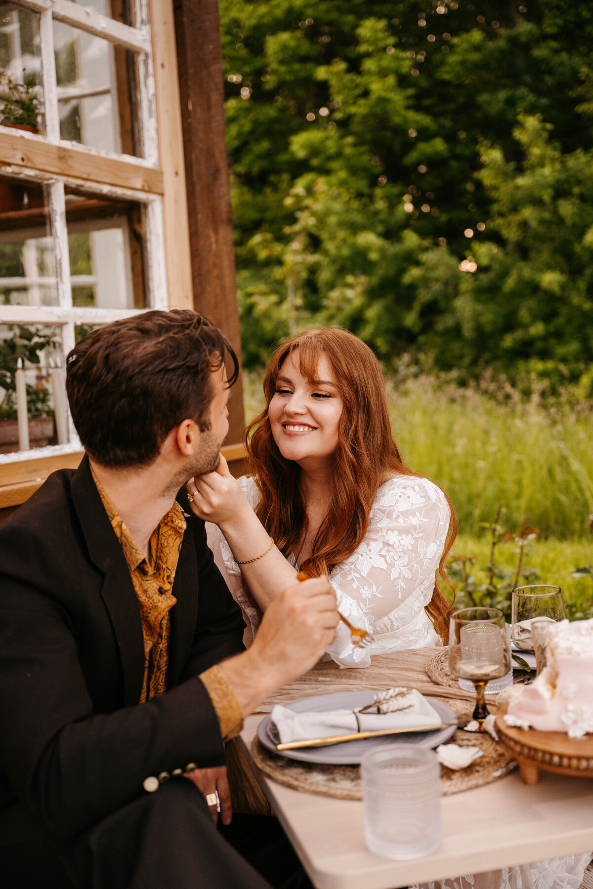 Bride smiles and holds grooms face at the reception. Elopement at The Greenhouse on Strawberry Lane | Nova Scotia