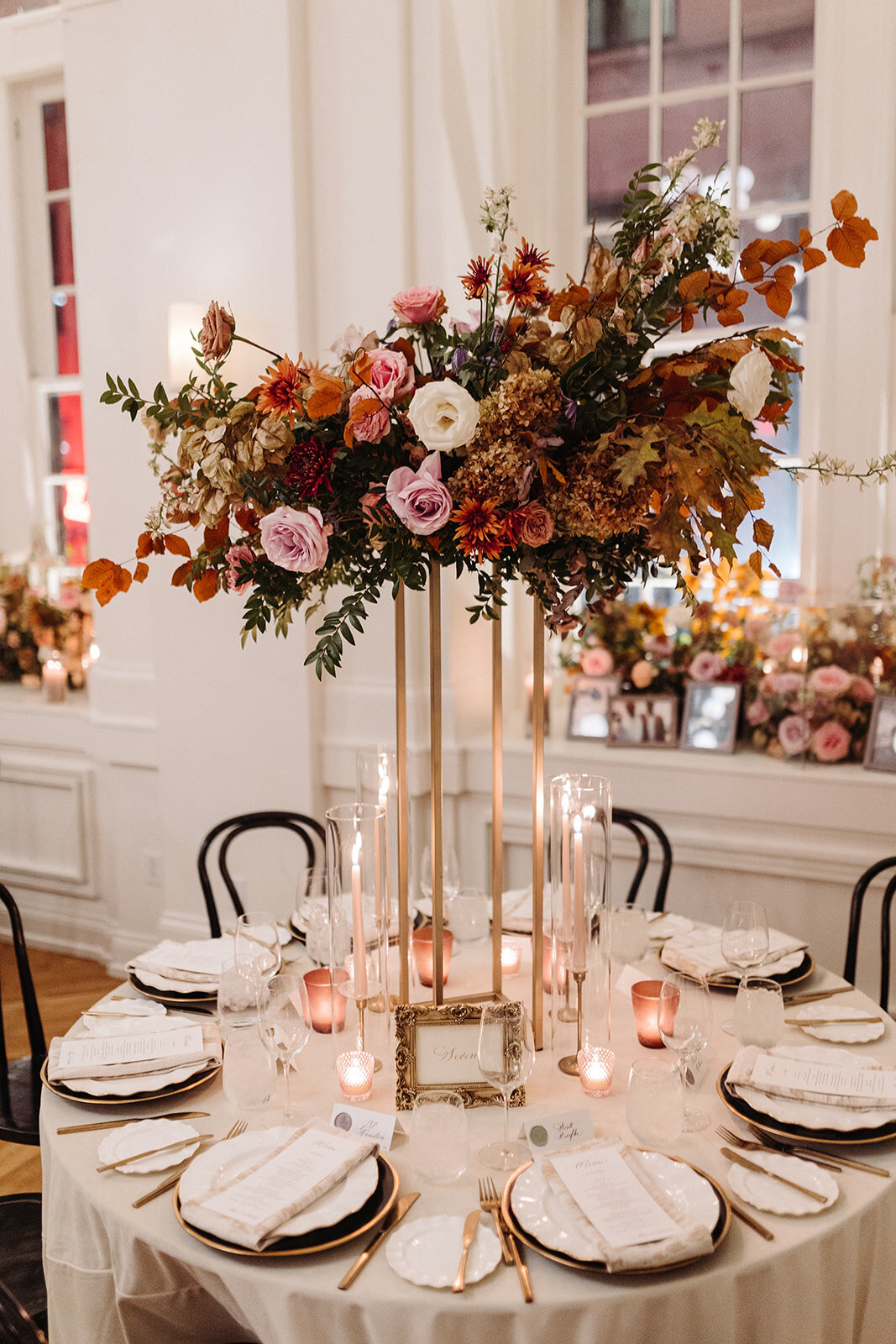 Eye-catching elevated centerpieces complete this Parisian inspired fall wedding with hues of dusty rose, terra cotta, burgundy, mauve, lavender, and copper composed of roses, mums, lisianthus, clematis, delphinium, copper beech, dried hydrangea, and fall foliage. Design by Rosemary and Finch in Nashville, TN.