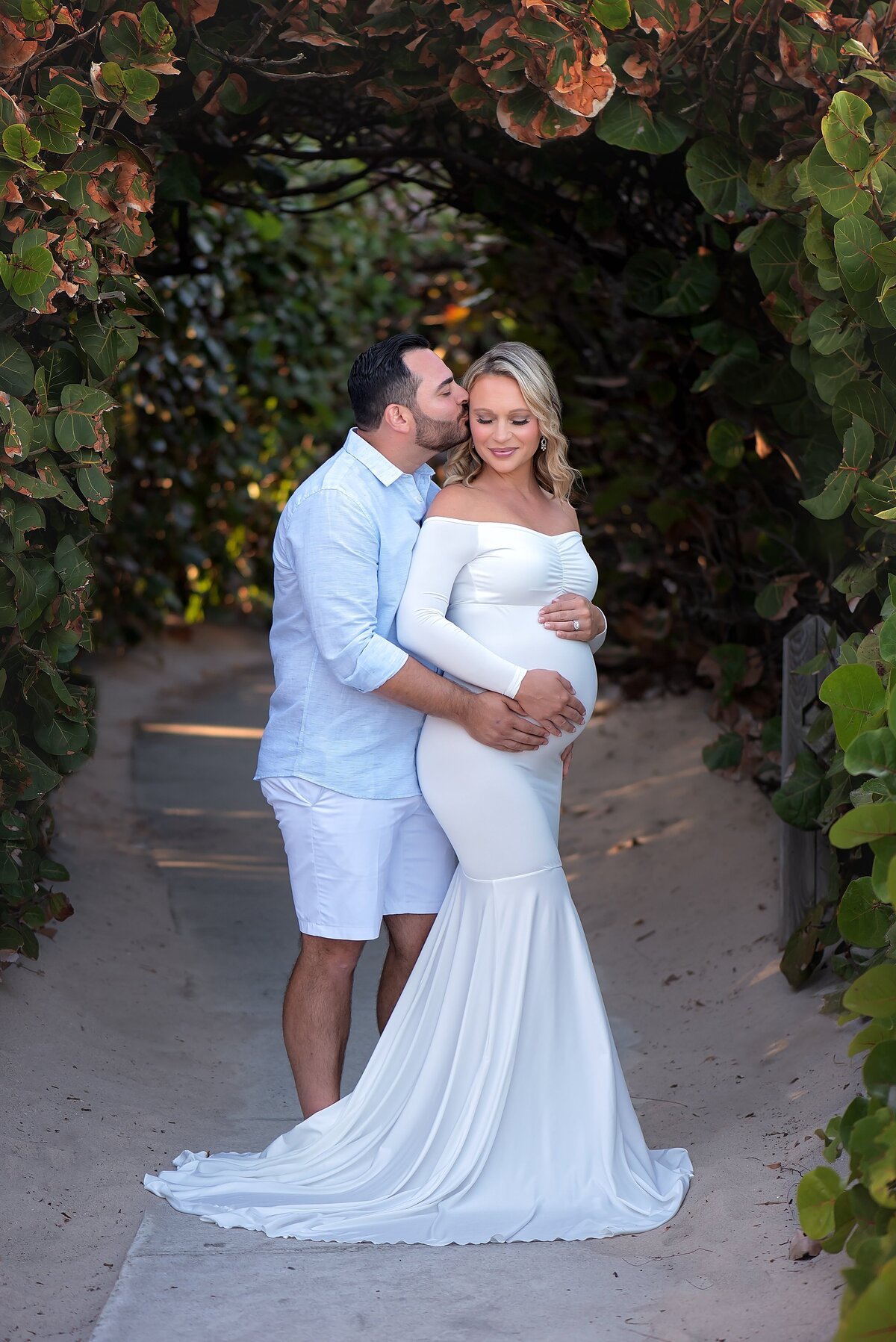 maternity couple at the beach with greenery