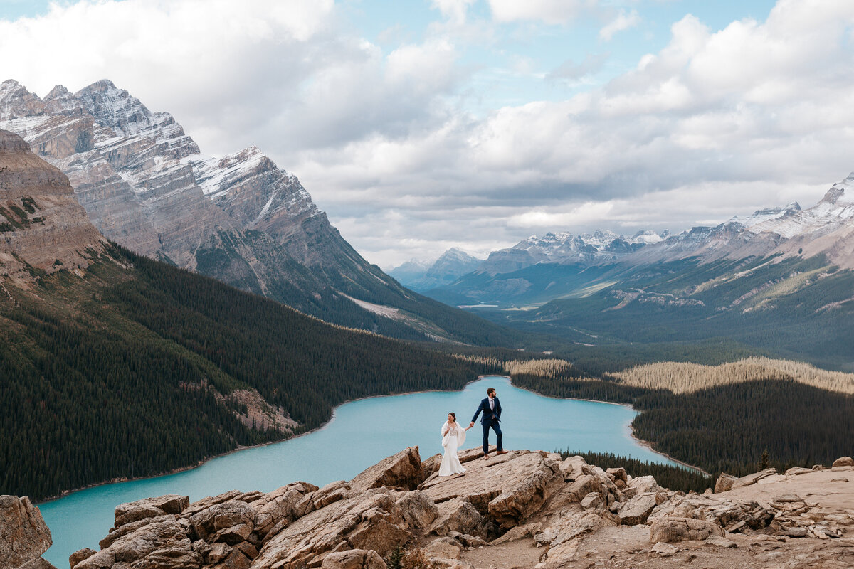 Couple holds hands overlooking Peyto Lake