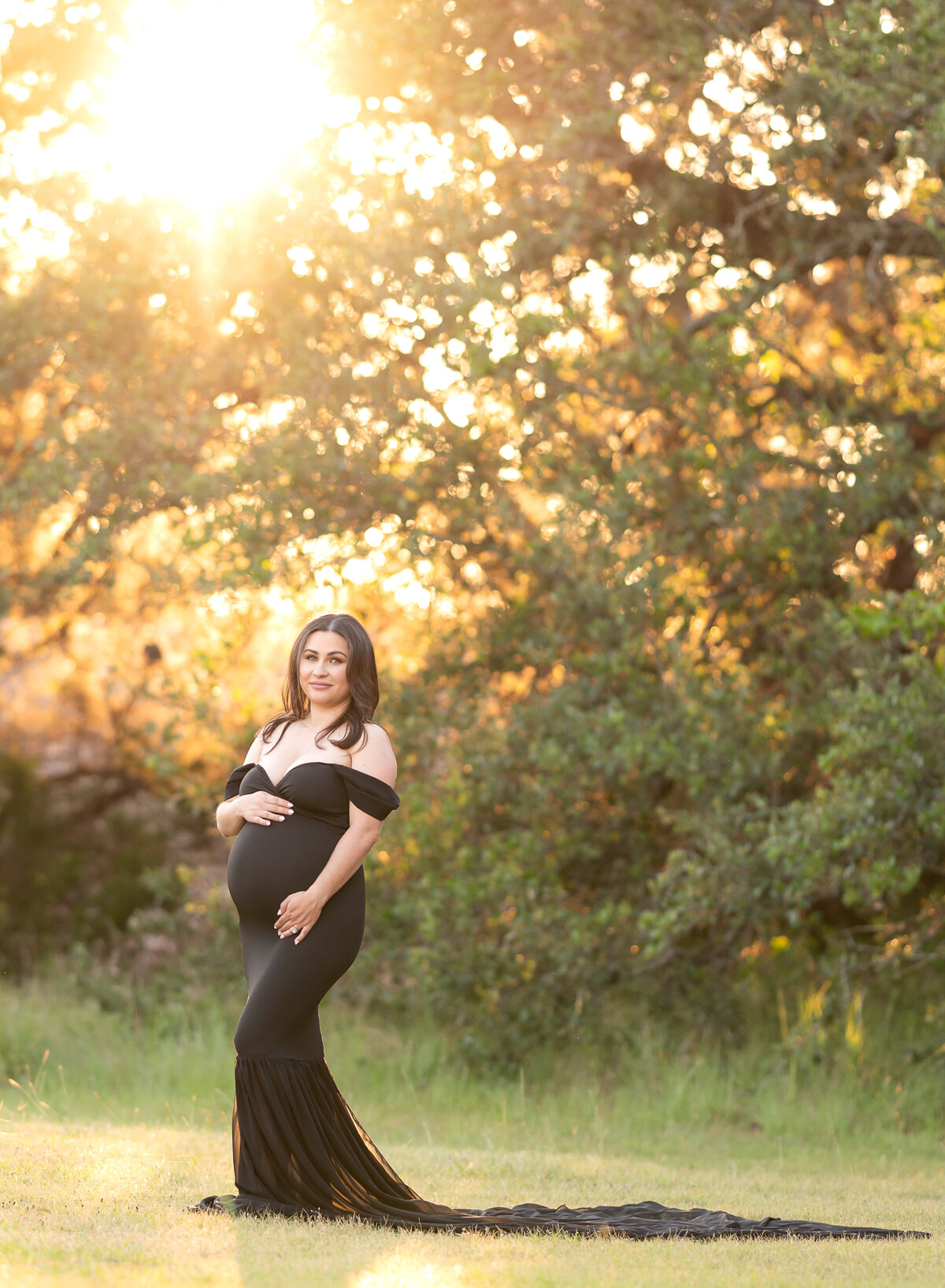pregnant woman wearing black fitted dress at sunset