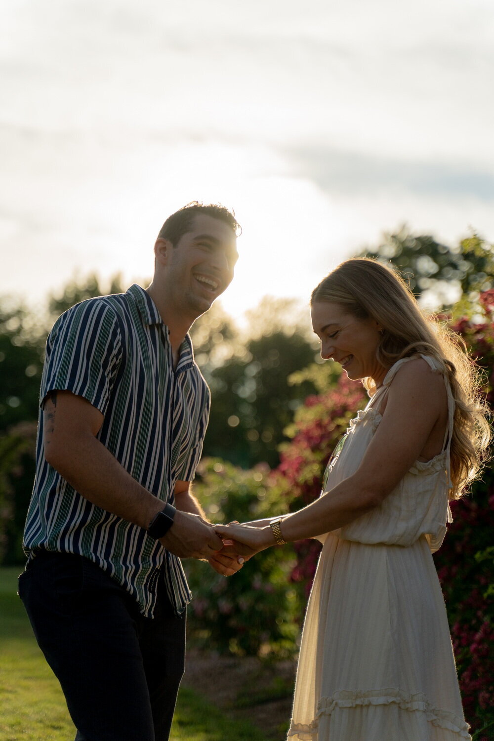 silhouettes of a couple holding hands and laughing in Elizabeth Garden during golden hour