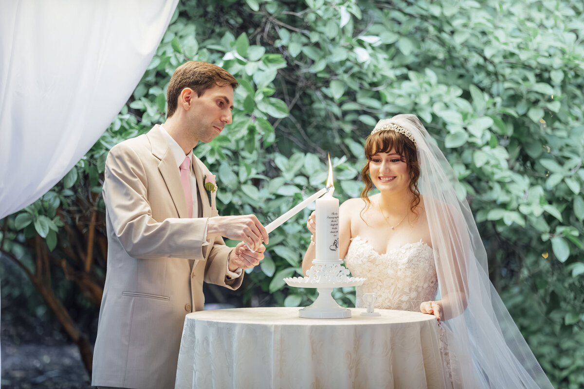 Olde Mill Inn | Bride and groom lighting unity candle during wedding ceremony | Basking Ridge, New Jersey