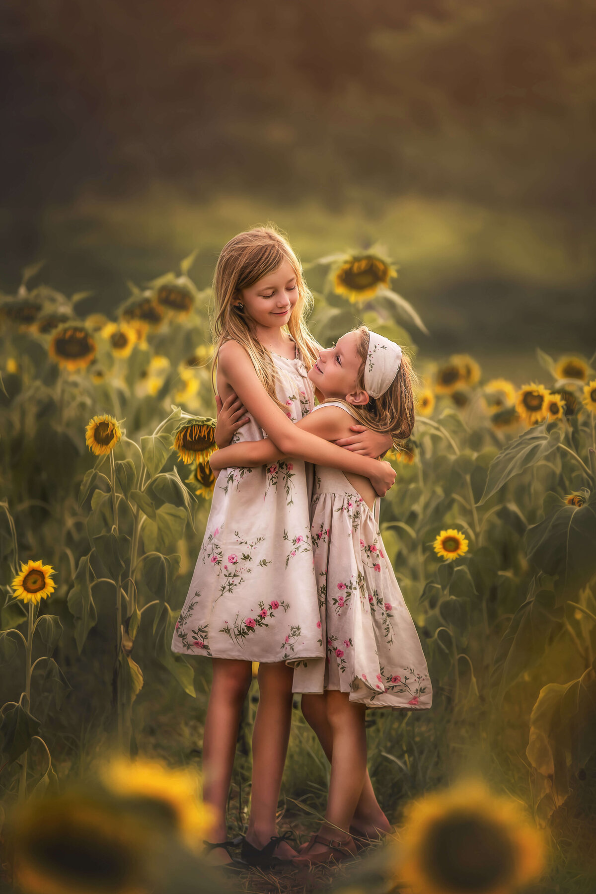 Sisters hugging in sunflower field