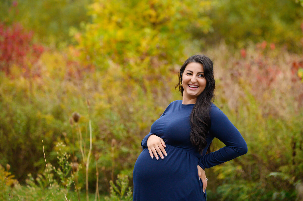Burlington, ON maternity photography session, pregnant woman wearing a blue maternity dress in the fall