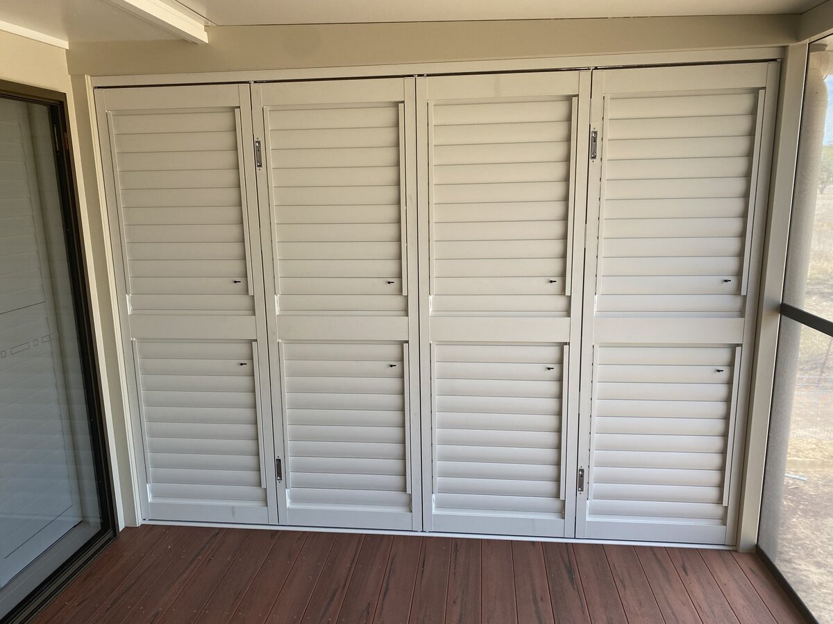 Outdoor patio enclosed with sliding shutters, ideal for ventilation and shade.