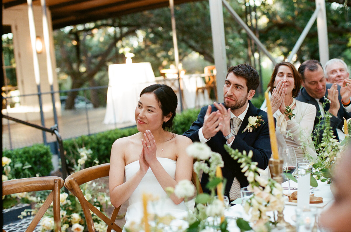 Bride and groom clapping after speech at Mattie's wedding in Austin