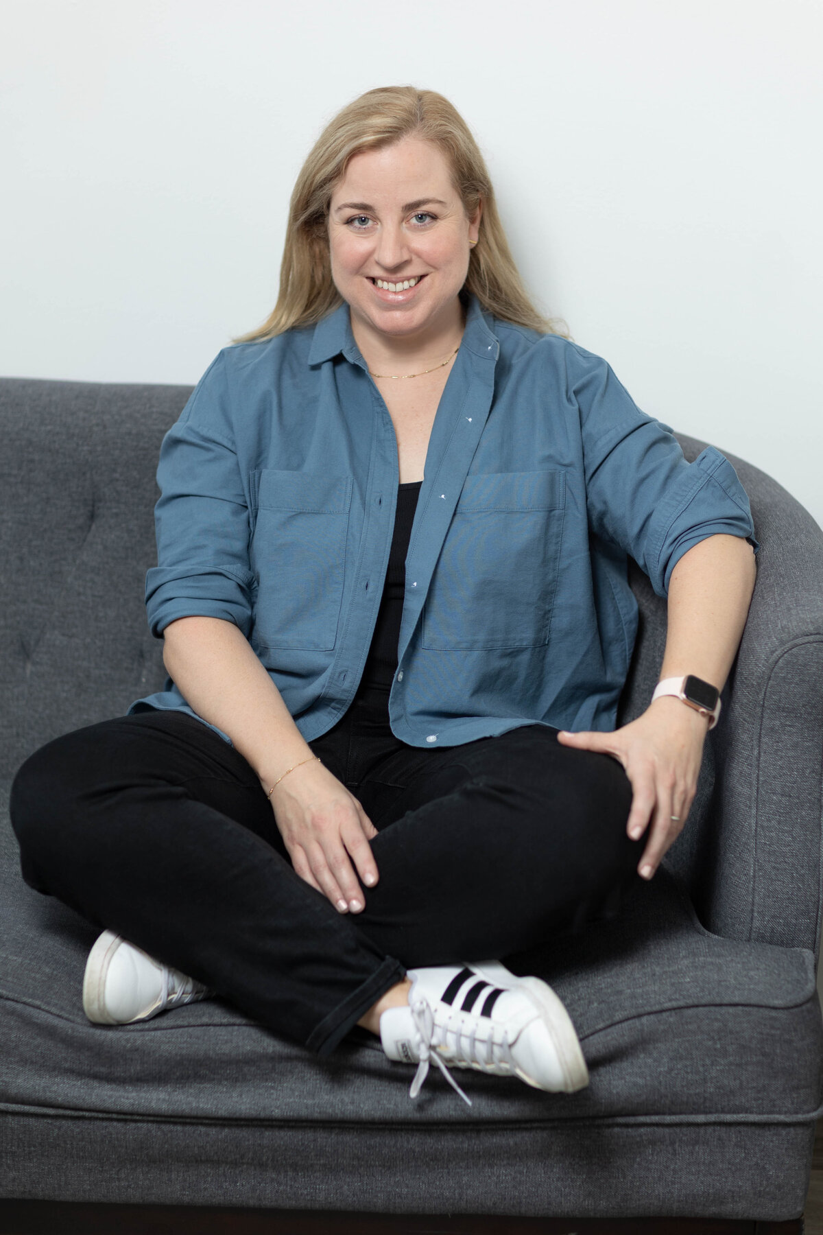 Woman sitting crosslegged on sofa