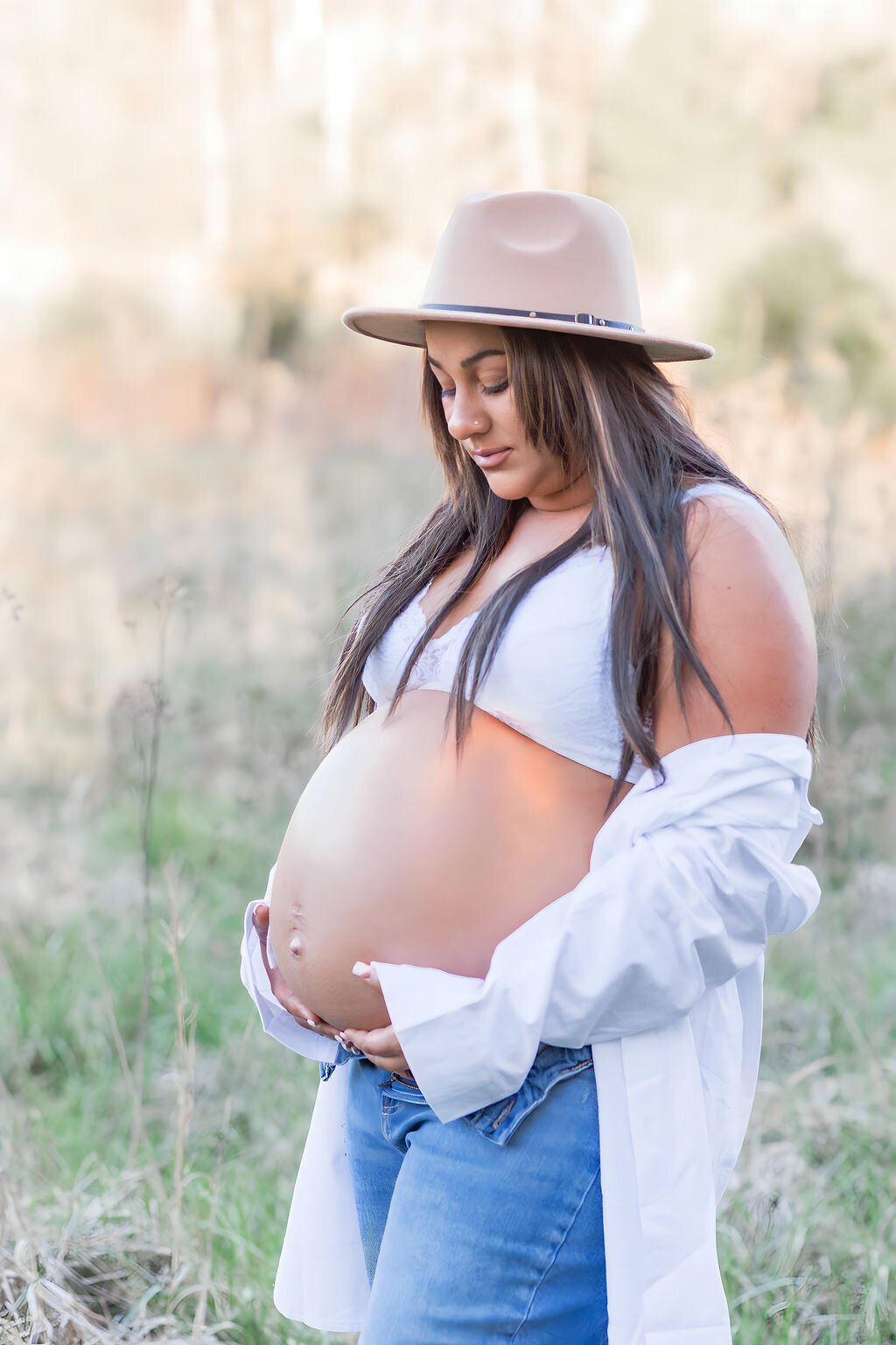 Mom holding baby bump during maternity session at Fisher Farm Park