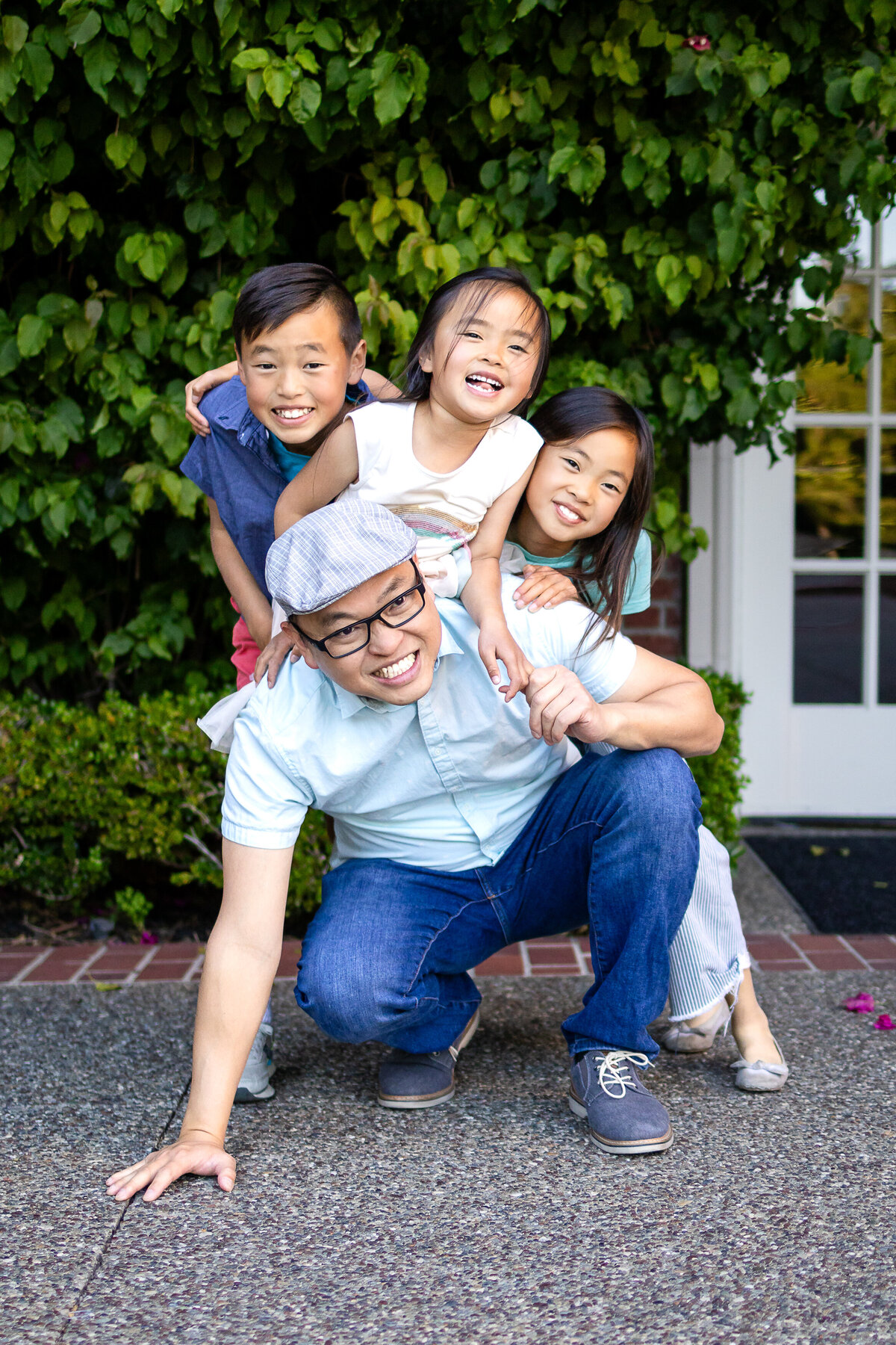 father and three kids Kohl mansion Burlingame Golden hour portrait of a family of five sitting down in rose garden – joyful, natural light family photography by Ellobelle Photography in the San Francisco Peninsula