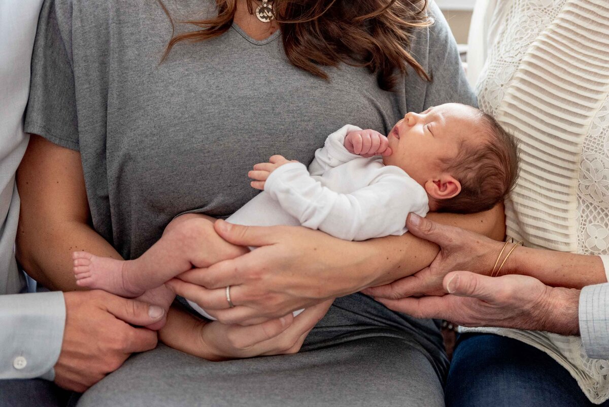 extended family hands on baby