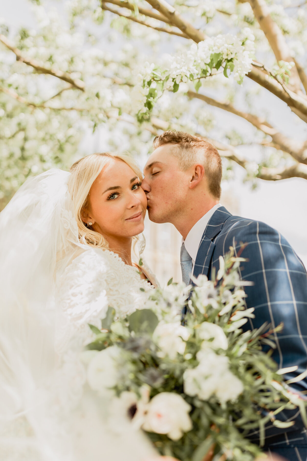Max kisses Jade on their wedding day at the Logan. Utah Temple on their summer wedding day