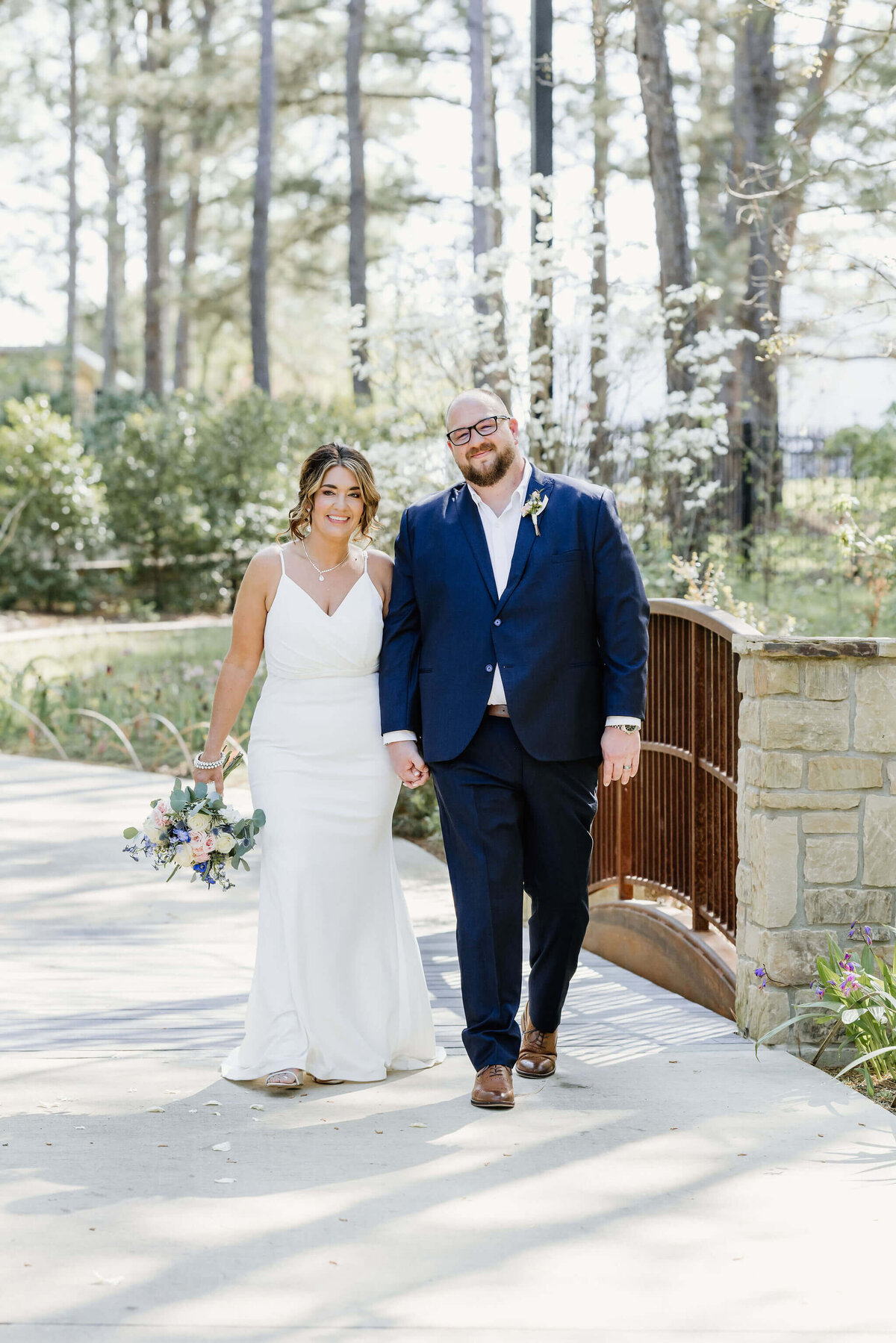 candid photo of bride and groom holding hands and walking through East Texas elopement venue after wedding ceremony