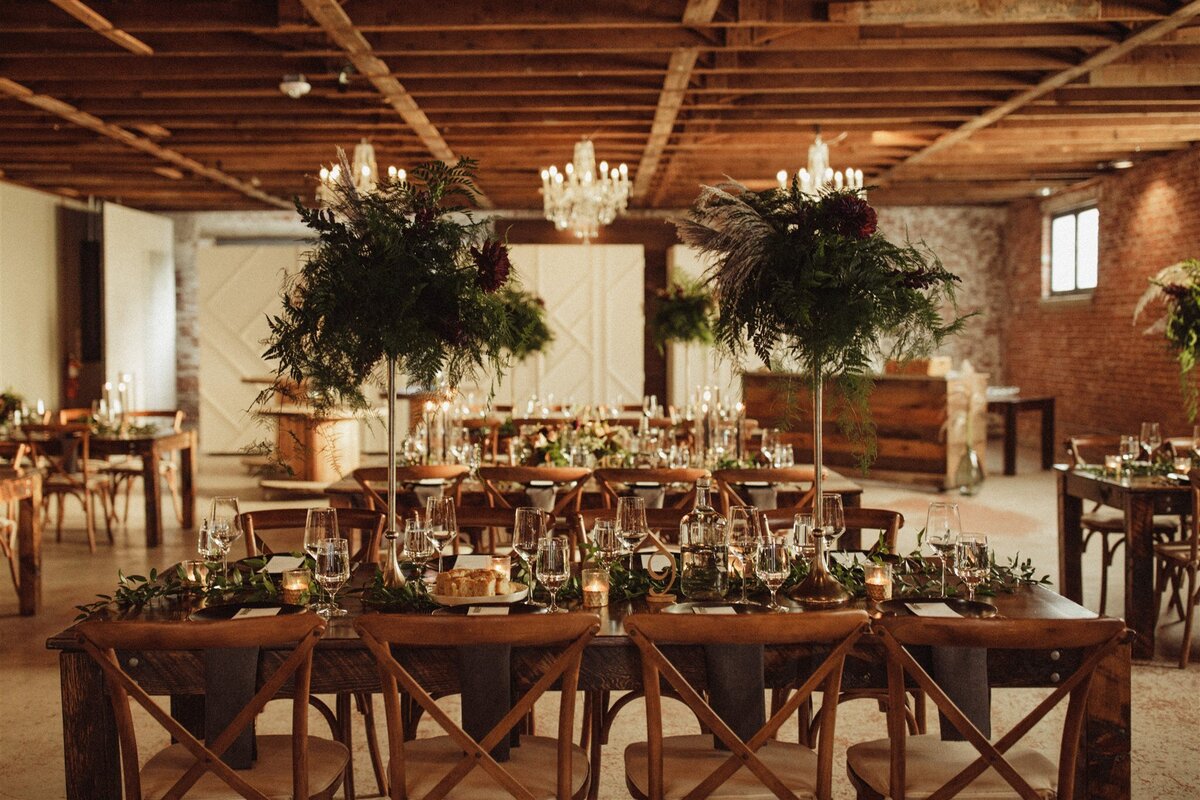 Wedding reception with greenery , candles and chandeliers