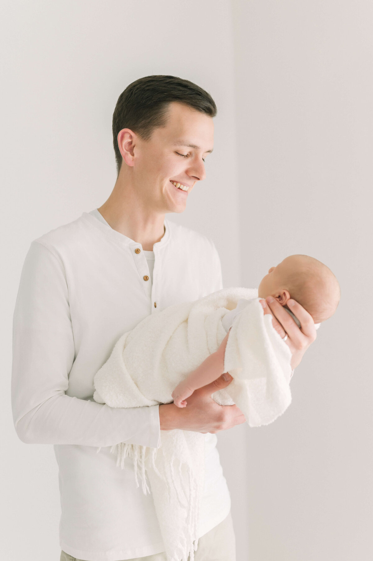 Father looking down at newborn baby boy