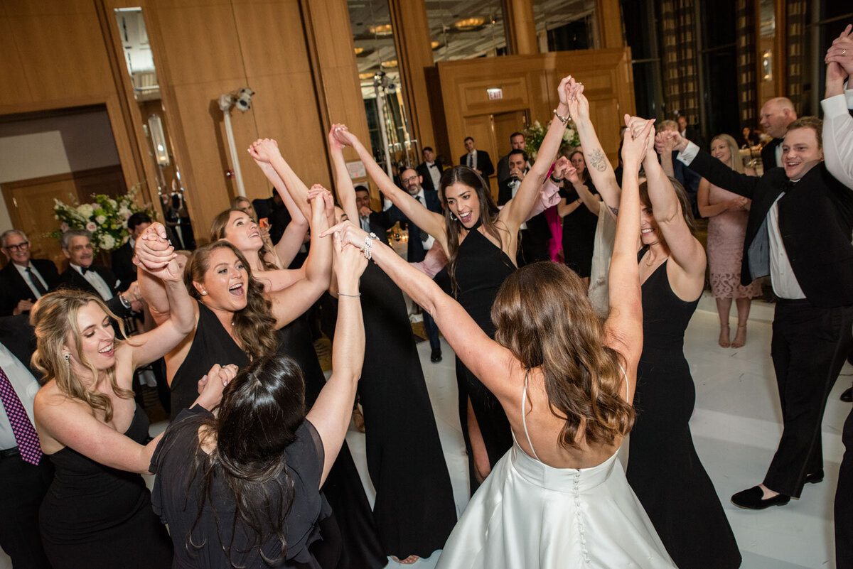 A group of women are dancing with their arms in the air
