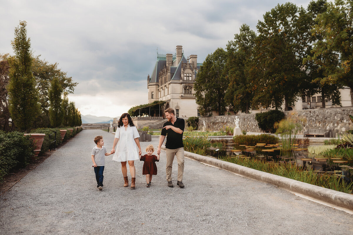 Family walks through the Italian garden at Biltmore Estate during their Family Portraits in Asheville, NC. 
