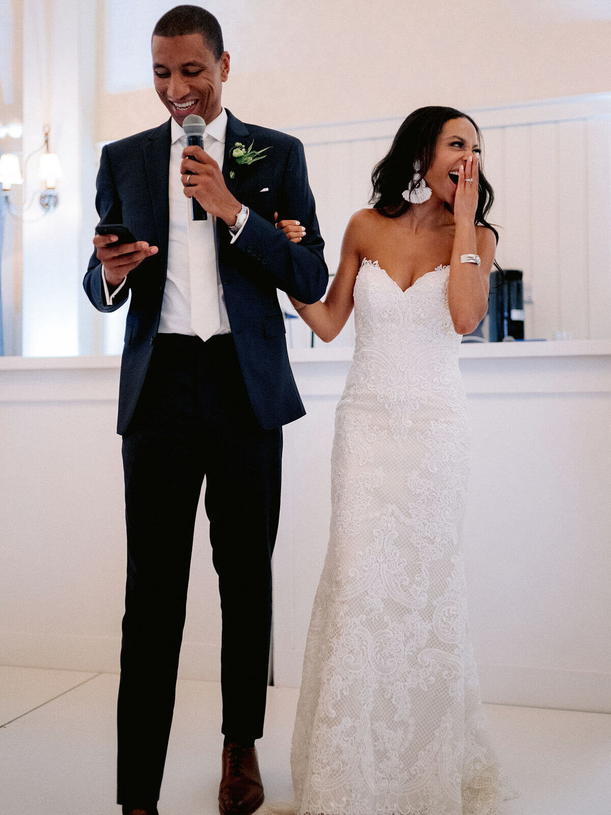 The groom is talking on the microphone while the bride gasps, in Montage at Palmetto Bluff. Destination Image by Jenny Fu Studio