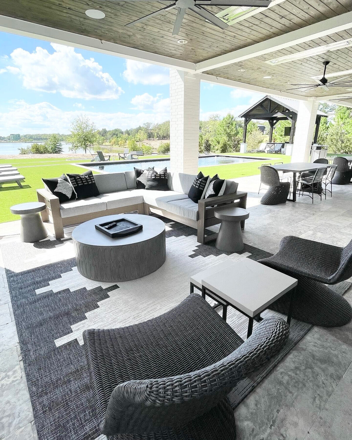 Professional home design contractor for an outside living room, decorated with grey and white decorations, creating a sophisticated and inviting space.