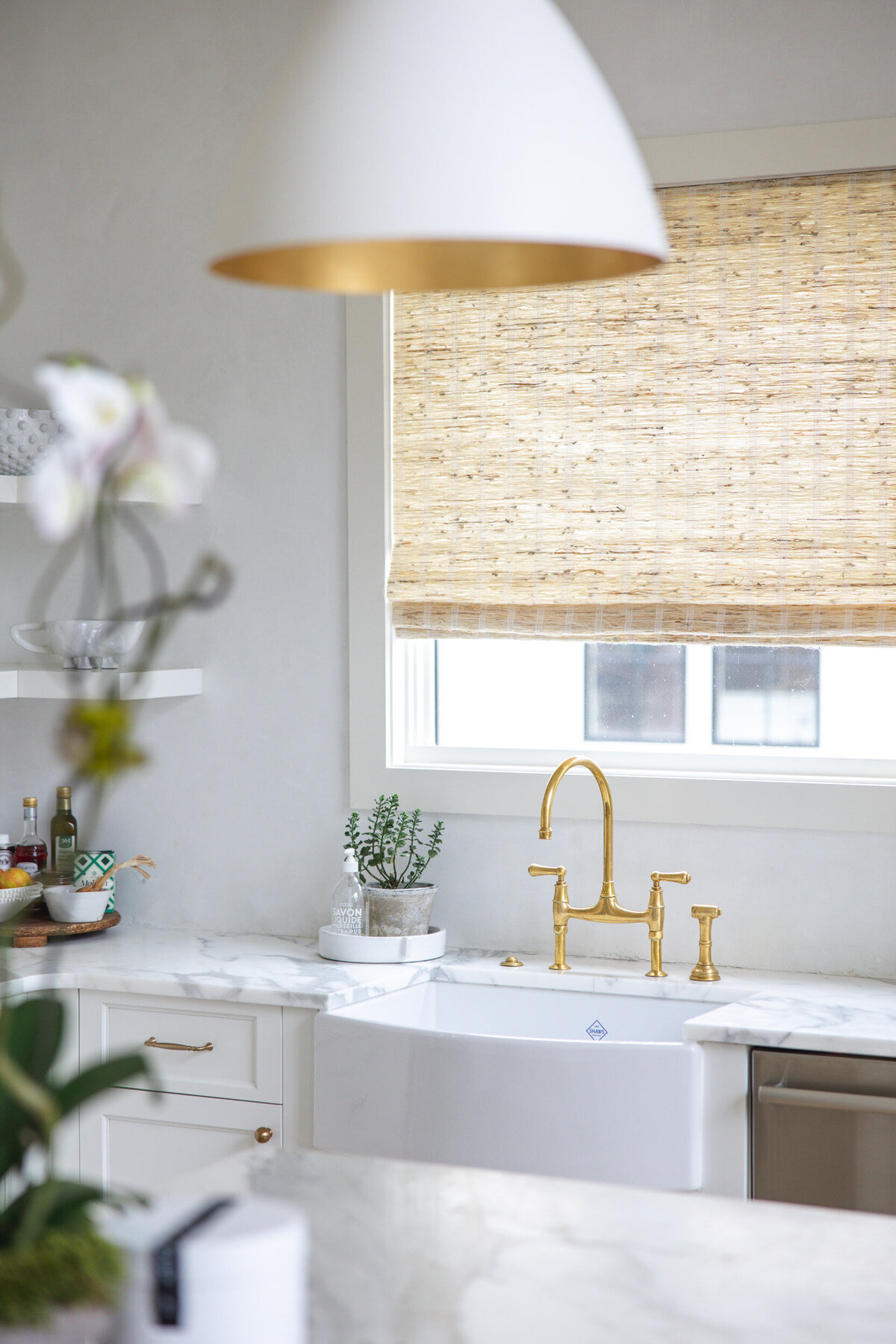 White farmhouse kitchen sink with gold faucet