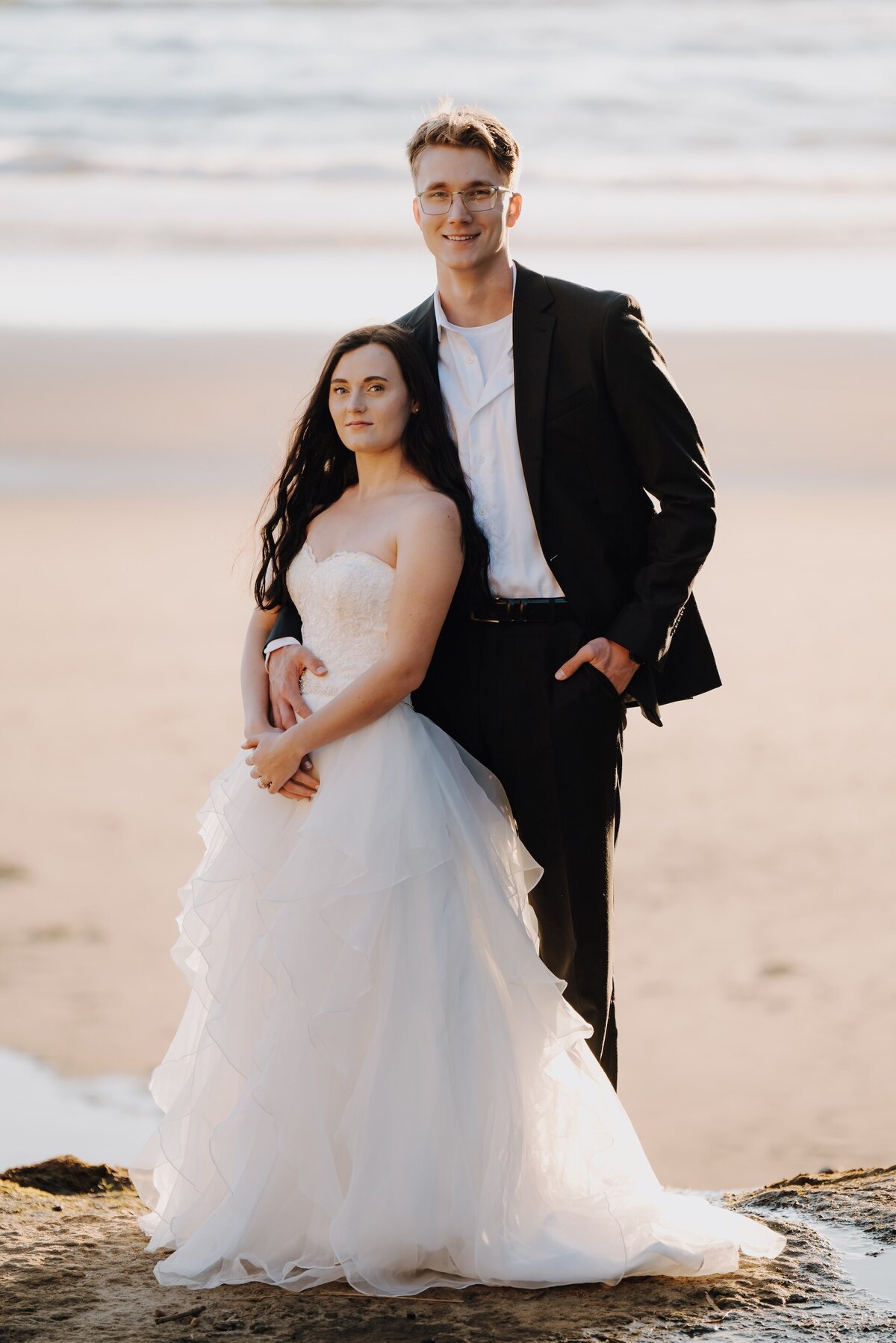 bride and groom posing on the beach