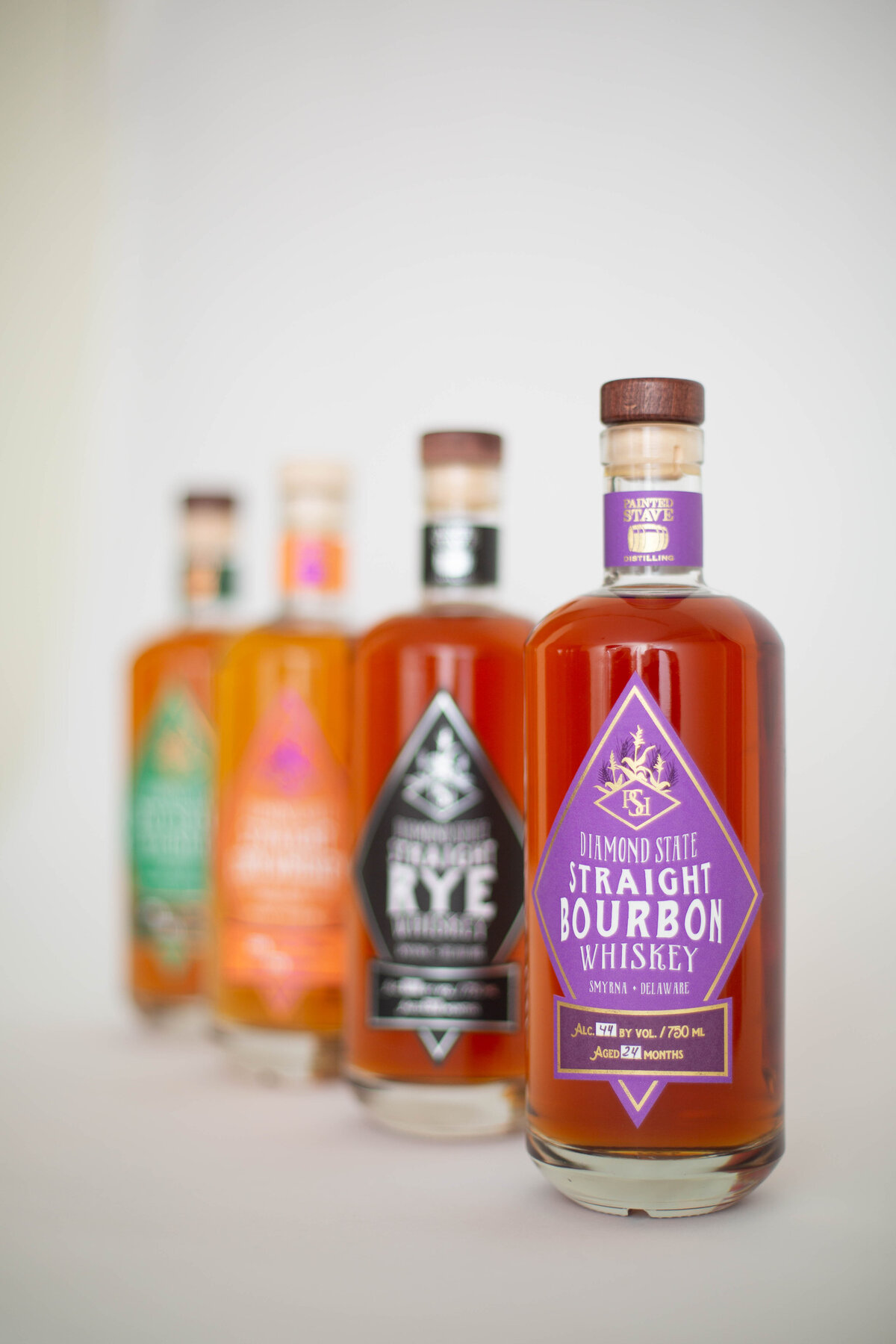 4 bourbon bottles lined up getting progressively less in focus